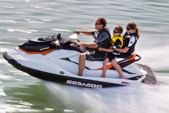 a man riding on the back of a boat in the water